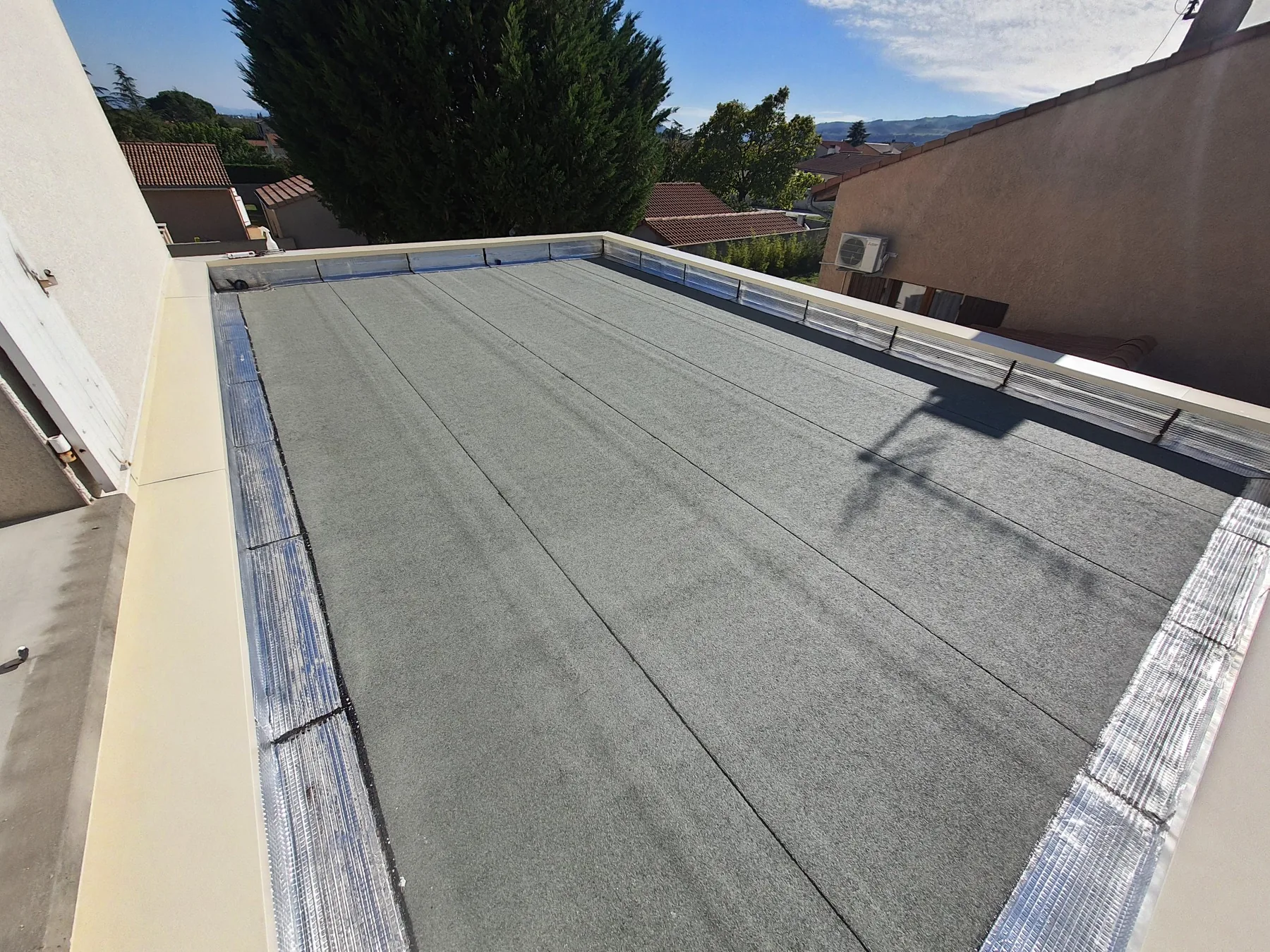 Toiture-terrasse d’une extension de maison : étanchéité bicouche autoprotégée, relevés et couvertines